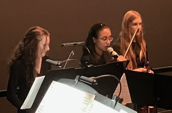 QC Youth Symphony Orchestra members Elise Brock, left, Haven O'Brian and Bethany Priaulx speaking during the "Violins of Hope" program at the Putnam Giant Screen Theater (photo by Jonathan Turner).