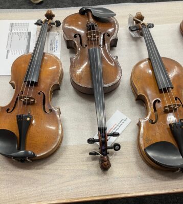 Three of the violins in the "Violins of Hope" exhibit, to be displayed at the Putnam Museum, Figge Art Museum, and German American Heritage Center + Museum in Davenport (photo by Jonathan Turner).