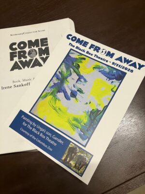 A copy of the Gander painting and score to "Come From Away."