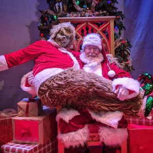 John as Santa Claus, with Sara Nicole Wegener as the Grinch, in December 2019.