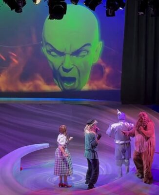 A climactic scene with a projected Wizard of Oz confronting Dorothy, Cowardly Lion, Tin Man and Scarecrow at Circa '21, directed by Tony Parise.