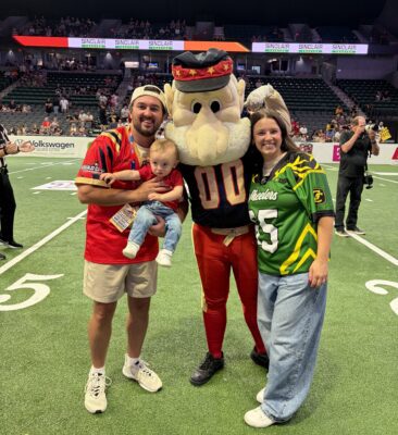 Colin and Lexie Gould with the Quad City Steamwheelers' mascot on the Vibrant Arena football field.
